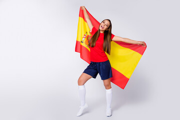 Full body photo of sports joyful addicted lady support soccer team 2020 league hold spain national flag symbol wear football uniform t-shirt shorts cleats socks isolated white color background - Powered by Adobe