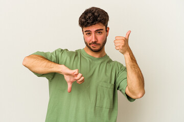 Young caucasian man isolated on white background showing thumbs up and thumbs down, difficult choose concept