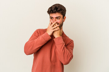 Young caucasian man isolated on white background laughing about something, covering mouth with hands.