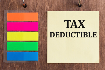 yellow card on the wooden background with text Tax Deductible