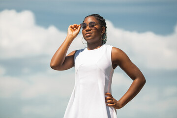 beautiful young african woman in white dress wearing sunglasses 