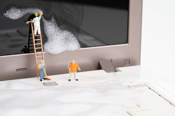 Miniature people cleaning up the computer