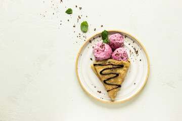 Ice cream cone close-up. Pink Icecream scoop in pancake cone over white background. Strawberry or raspberry flavor Sweet dessert decorated with colorful sprinkles, closeup, with space for text.