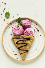 Ice cream cone close-up. Pink Icecream scoop in pancake cone over white background. Strawberry or raspberry flavor Sweet dessert decorated with colorful sprinkles, closeup, with space for text.