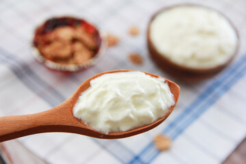 white milk yogurt in a wooden spoon