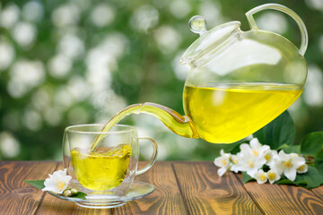 jasmine tea pouring from flying teapot into glass cup