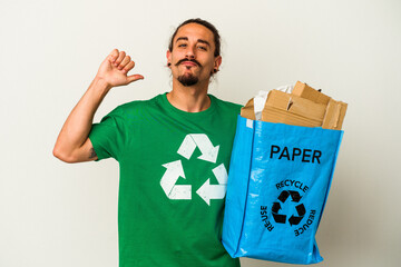 Young caucasian man with long hair recycling cardboard isolated on white background feels proud and self confident, example to follow.