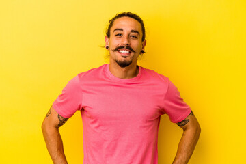 Young caucasian man with long hair isolated on yellow background happy, smiling and cheerful.