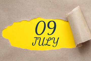 july 09. 09th day of the month, calendar date.Hole in paper with edges torn off. Yellow background is visible through ragged hole.Summer month, day of the year concept