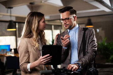 Colleagues talking in the office. Businesswoman and businessman discussing work in office..