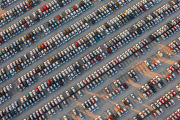 Fototapeta premium Aerial top down view of brand new cars at the logistics center, near the factory. Ready to export or import. Car parking lot.