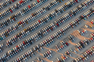 Obraz premium Aerial top down view of brand new cars at the logistics center, near the factory. Ready to export or import. Car parking lot.