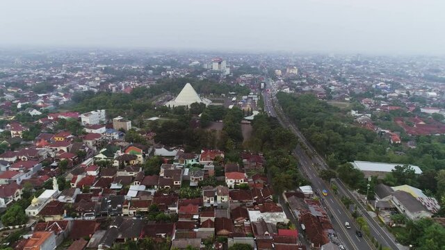 Aerial footage landscape view of city with building, green trees and main road