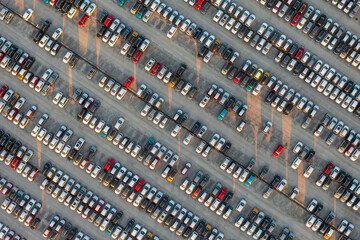 Aerial top down view of brand new cars at the logistics center, near the factory. Ready to export or import. Car parking lot.