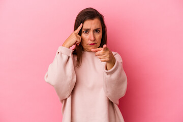 Middle age caucasian woman isolated on pink background pointing temple with finger, thinking, focused on a task.