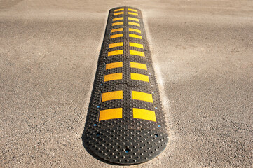 sleeping policeman on black and yellow asphalt
