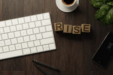 Work from home. desk office with keyboard, RISE wooden cubes, coffee cup and pen on wood table. Flat top view