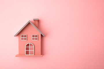 Small wooden toy house on pink background - obrazy, fototapety, plakaty