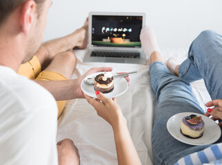 Portrait of her she his he nice attractive cheerful cheery glad friends friendship sitting on bed watching comedian show TV at modern industrial loft style brick interior living-room flat