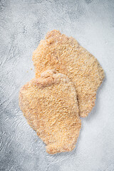 Fototapeta na wymiar Raw chicken schnitzel Escalope in breadcrumbs. White background. Top view