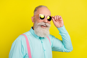 Photo portrait of old man wearing sunglass in shirt suspenders smiling isolated bright yellow color...