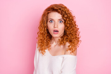Photo portrait of red haired curly woman staring amazed with opened mouth isolated on pastel pink...