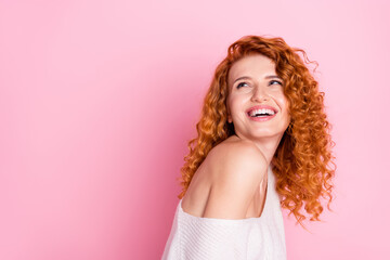 Photo portrait of red curly haired girl smiling with off-shoulder laughing looking blank space isolated pastel pink color background