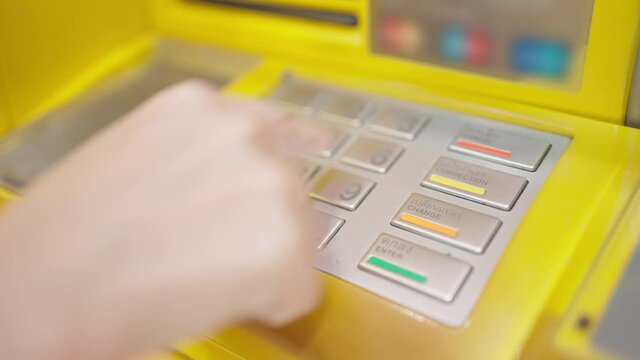 Side view of caucasian woman hand entering put the passcode on the ATM machine keypad at the bank. Use personal identification number. Finance, technology and security concept. 