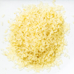 pile of raw parboiled rice close up on gray
