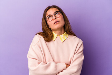 Fototapeta premium Young caucasian woman isolated on purple background tired of a repetitive task.