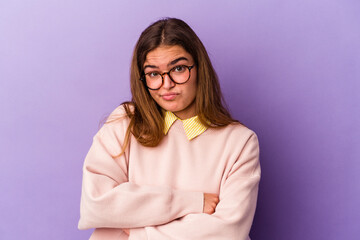 Young caucasian woman isolated on purple background unhappy looking in camera with sarcastic...