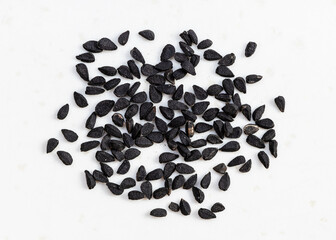 several Nigella sativa seeds close up on gray