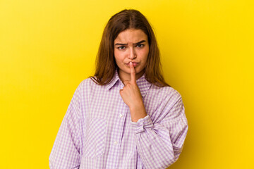 Young caucasian woman isolated on yellow background thinking and looking up, being reflective, contemplating, having a fantasy.