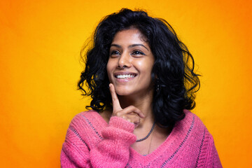 Beautiful Sri Lanka girl poses standing with yellow bright background- Young woman smiles