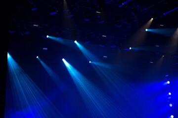 Fototapeta na wymiar Blue stage lights glowing in the dark