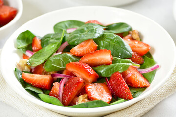 Healthy breakfast with fruit salad from strawberry, basil and walnut
