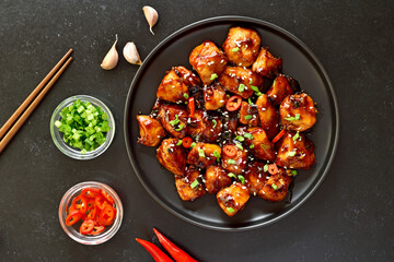 Easy teriyaki chicken on plate over black stone background