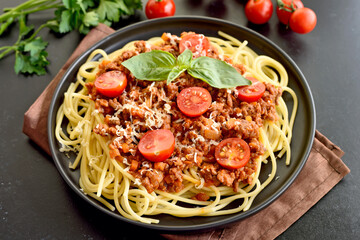 Tasty spaghetti with minced meat, cherry tomatoes and parmesan cheese on plate