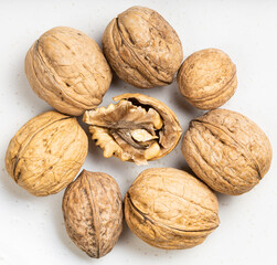 several shelled and whole walnuts close up on gray
