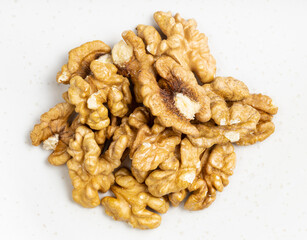 top view of pile of shelled walnuts on gray