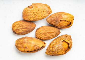 several almond seeds and drupes close up on gray