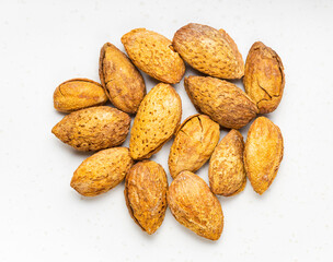 pile of cracked almond drupes close up on gray