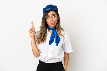 Airplane stewardess over isolated white background with fingers crossing and wishing the best