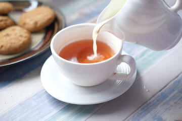 close up of pouring milk in a tea cup 