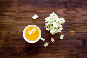 Cup of jasmine herbal tea with white flowers. Top view