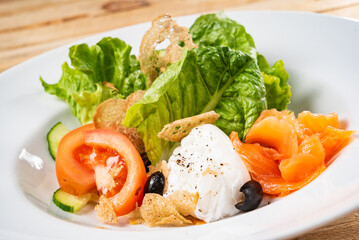 salad with mozzarella and salmon, wooden background