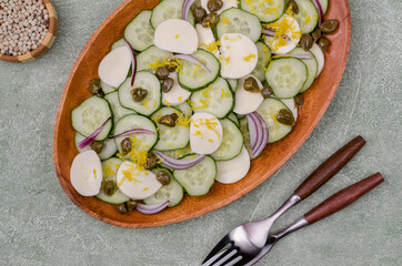 Salad of cucumbers, cheese, capers and lemon zest