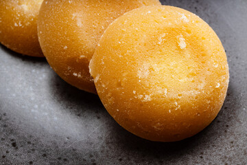 whole round pieces of palm sugar close up on black