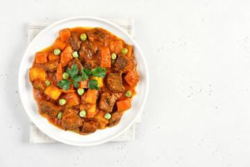 Beef stew with potatoes and carrots in tomato sauce