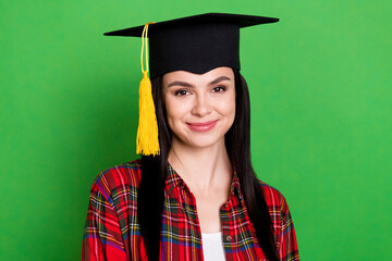 Photo of brunette optimistic lady celebrating wearing graduate cap red shirt isolated on green color background